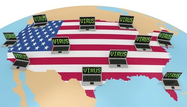 A 3D rendering of the United States map overlaid on a globe. Several laptops, each displaying the word "VIRUS" on their screens, are scattered across the country.